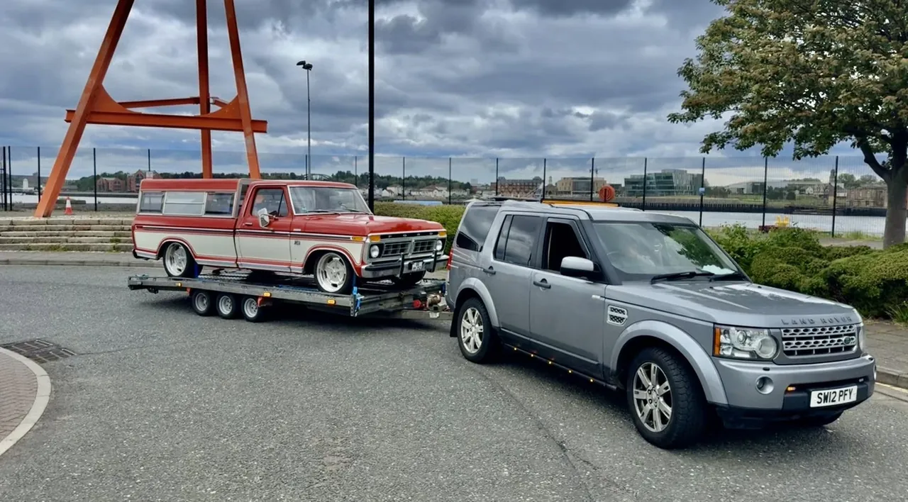 DSBM Land Rover Discovery transporting a classic Ford on a vehicle trailer